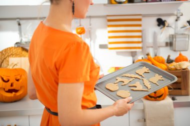 Closeup on woman with tray of uncooked Halloween biscuits