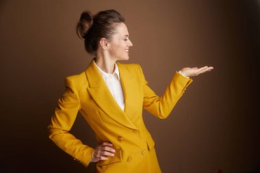 Sarı ceketli, kendine güvenen bir iş kadını, gülümseyerek elini uzatıyor, yeni bir iş fikri sunuyor, işbirliğini hoş karşılıyor, ya da bir çözüm öneriyor..