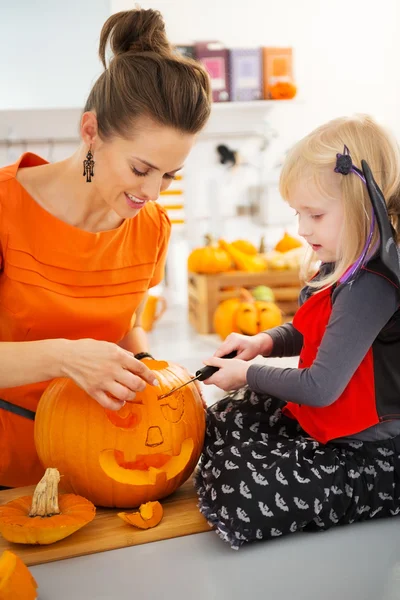 Mãe com filha esculpir Jack-O-Lanterna para festa de Halloween — Fotografia de Stock
