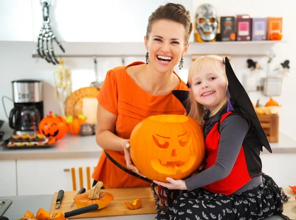 Mother with daughter holding big orange pumpkin Jack-O-Lantern — 스톡 사진