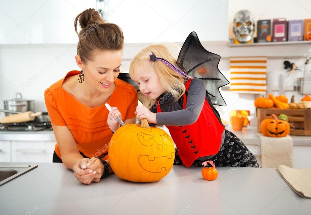 Mother with daughter creating Jack-O-Lantern on Halloween Stock Photo ...