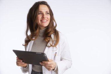 Bu görüntü laboratuvar önlüğü giymiş, elinde dijital tabletle yukarı bakan gülümseyen bir kadın doktoru gösteriyor. Modern sağlık, teknoloji ve hasta danışmanlığını güvenle iletir..