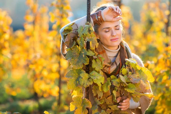 Avslappnad kvinna winegrower står i vingården utomhus på hösten — Stockfoto