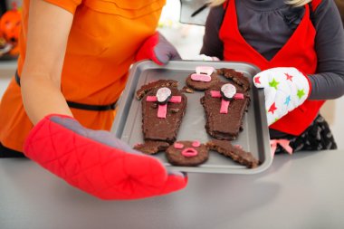 Closeup on Halloween cookies in hands of girl and mother