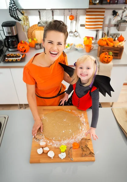 Mother with daughter in bat costume making Halloween cookies — Stock Photo, Image