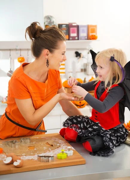 Halloween dressed girl with mother holding uncooked biscuits — Stok fotoğraf