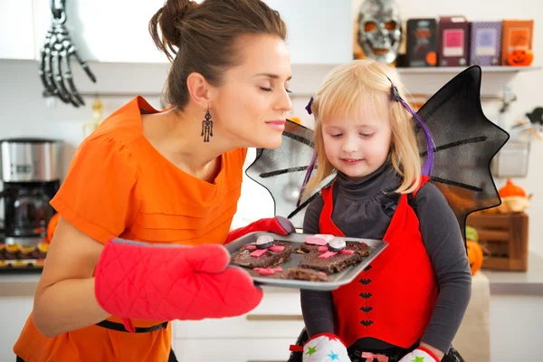 Дівчина з матір'ю насолоджується ароматом печива на Хелловін — стокове фото