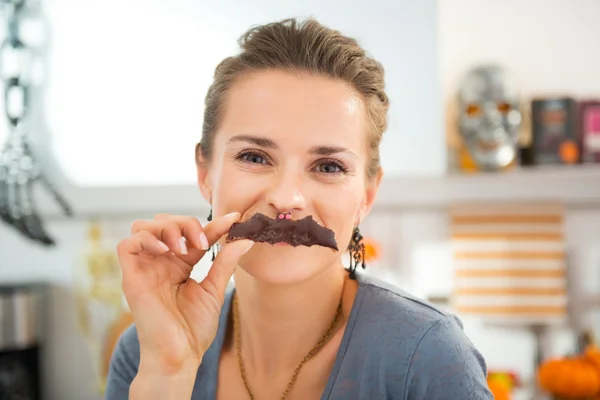 Femme au foyer moderne drôle faisant moustache avec biscuit d'Halloween — Photo