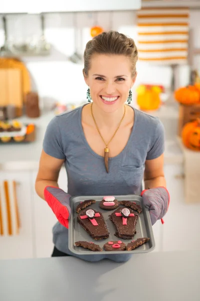 Lächelnde Frau hält Tablett mit hausgemachten Halloween-Keksen in der Hand — Stockfoto