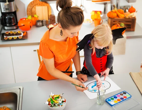 Halloween dressed girl with mother drawing Jack-O-Lantern — Stock Photo, Image