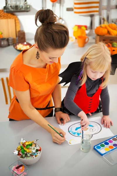 Dziewczyna w halloween kostium nietoperz z matka rysunek Jack-O-Lantern — Zdjęcie stockowe