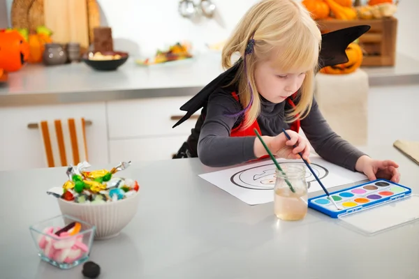 Интересный Хэллоуин одетая девушка рисует тыкву Джек-Фонарь — стоковое фото