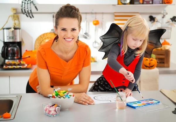 Madre con niña en traje de Halloween dibujo Jack-O-Lantern —  Fotos de Stock