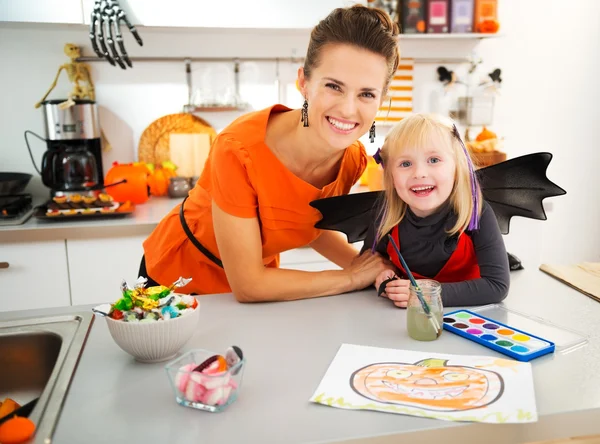Girl in bat costume with mother creating halloween decorations — Stock Photo, Image
