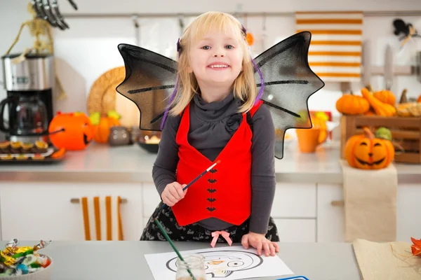 Dívka v halloween bat kostým výkresu Jack-O-Lantern na papíře — Stock fotografie