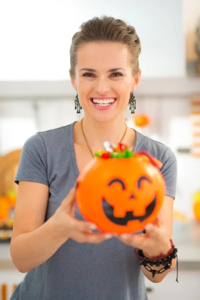 Mujer sosteniendo cubo de Halloween lleno de truco o caramelo tratar —  Fotos de Stock
