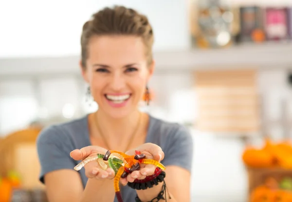 Close-up op kleurrijke Halloween Gummy worm snoepjes in vrouw handen — Stockfoto