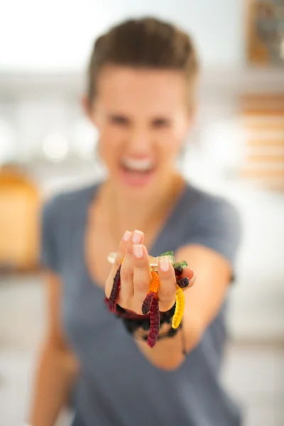 Крупный план на красочный Хэллоуин конфеты жевательный червь в руках женщины — стоковое фото