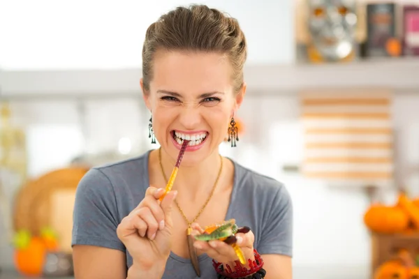 Young woman eating halloween gummy worm candies — Stock Photo, Image