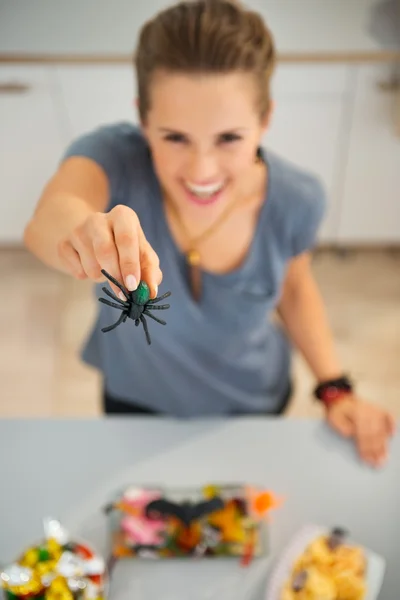 Крупный план игрушки-паука в руке женщины, готовящей угощение на Хэллоуин — стоковое фото