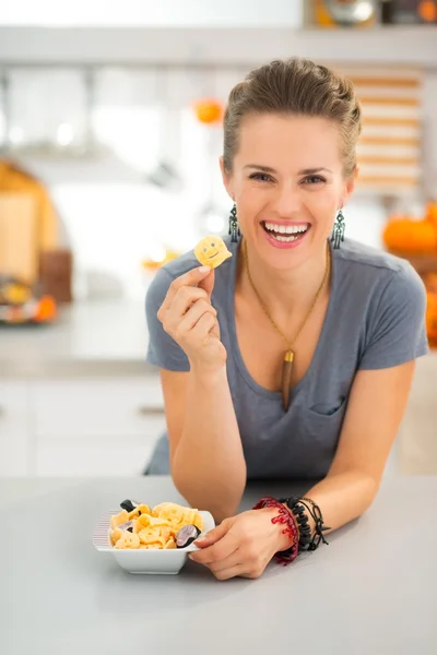 Feliz joven mujer en la cocina mostrando halloween boo chips trata —  Fotos de Stock