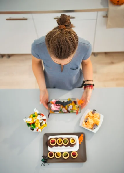 Woman in kitchen preparing halloween trick or treat — ストック写真