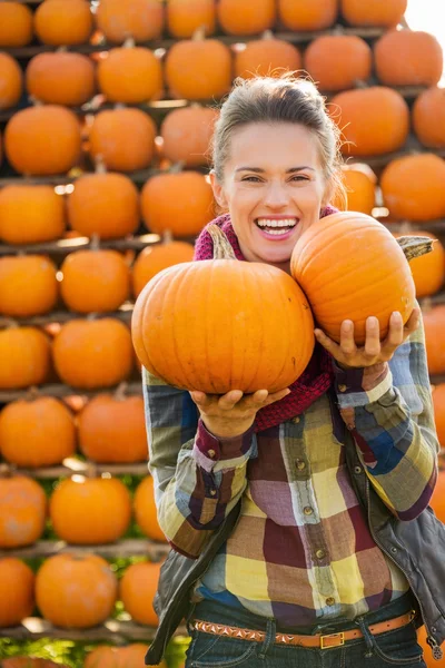 Portrait of smiling beautiful woman holding pumpkins on farm — Stock Photo, Image