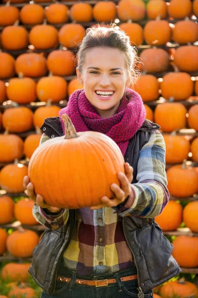 Retrato de una hermosa mujer sonriente sosteniendo calabazas en la granja — Foto de Stock