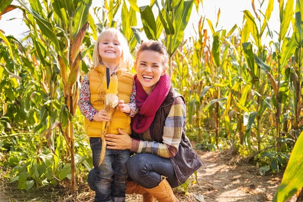 Portret van gelukkige moeder en kind verblijft in maïsveld op boerderij — Stockfoto