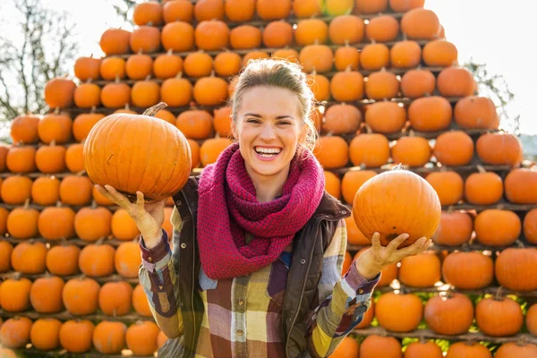 Retrato de mujer sonriente sosteniendo calabazas en otoño al aire libre —  Fotos de Stock