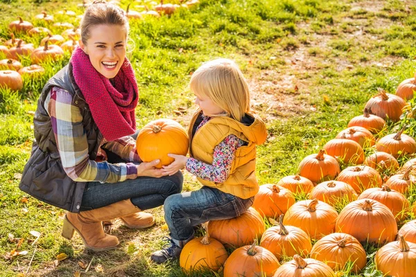 Усміхнена жінка і дитина вибирають гарбуз на фермі — стокове фото