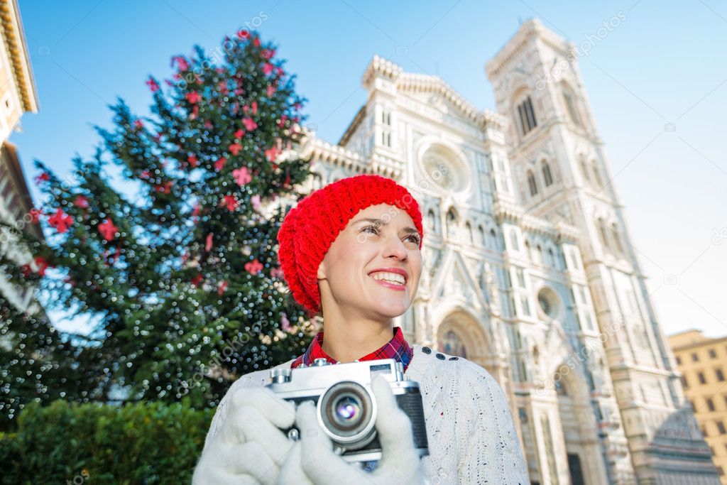 Woman holding photo camera near christmas tree in Florence