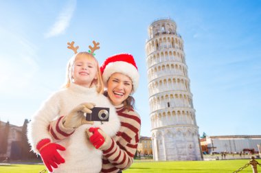 Happy mother and daughter taking photo. Christmas in Pisa