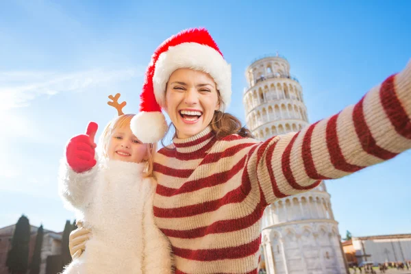 Mother in Christmas hat taking selfie with daughter in Pisa — Zdjęcie stockowe
