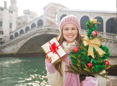 Happy woman with Christmas tree and gift box in Venice, Italy