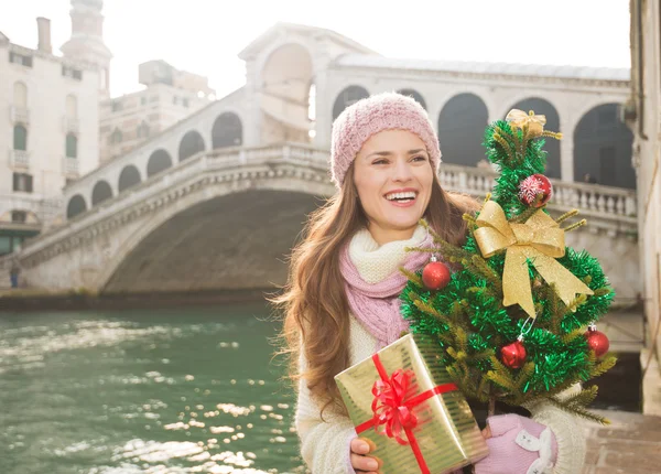 Улыбающаяся женщина с елкой и подарочной коробкой в Венеции, Италия — стоковое фото