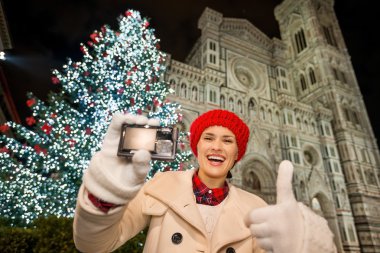Woman showing camera and thumbs up in Christmas Florence, Italy