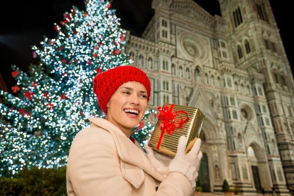 Giovane donna con scatola regalo vicino all'albero di Natale a Firenze — Foto Stock