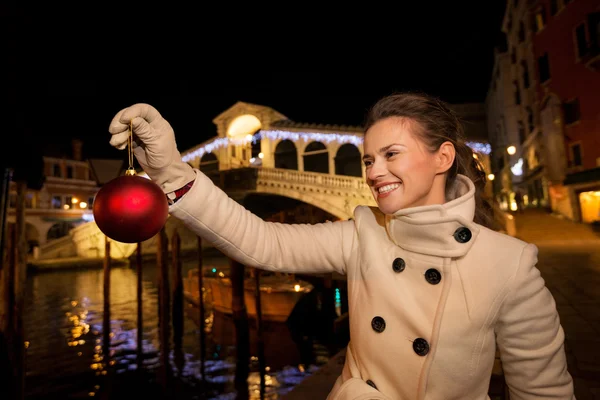 Young woman holding Christmas Ball near Rialto Bridge in Venice — Stockfoto