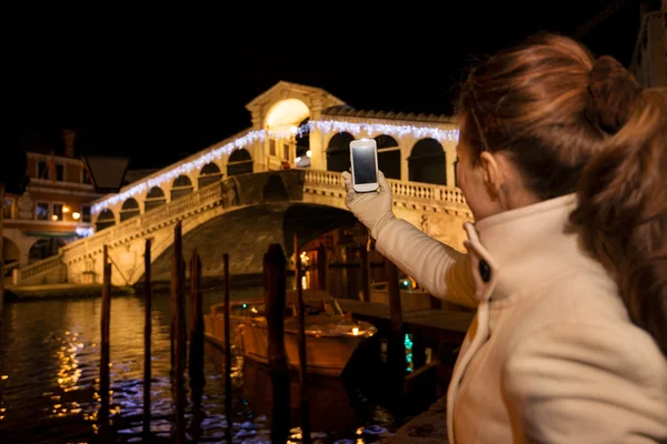 Woman taking photo of Rialto Bridge in Christmas Venice, Italy — стокове фото