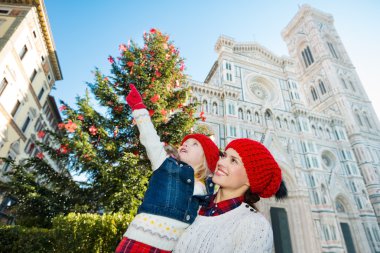 Mother and daughter pointing on something in Christmas Florence