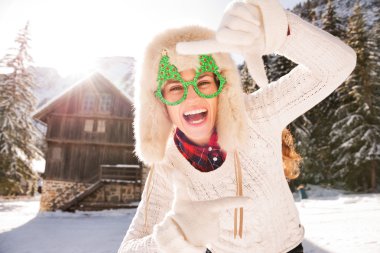 Eller ile çerçeveleme Noel gözlüklü kadın kırsal kesimde