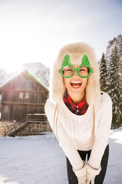 Jovem mulher em copos de Natal na frente de uma casa de montanha — Fotografia de Stock