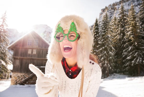 Kvinna i jul glasögon pekar på något på landsbygden — Stockfoto