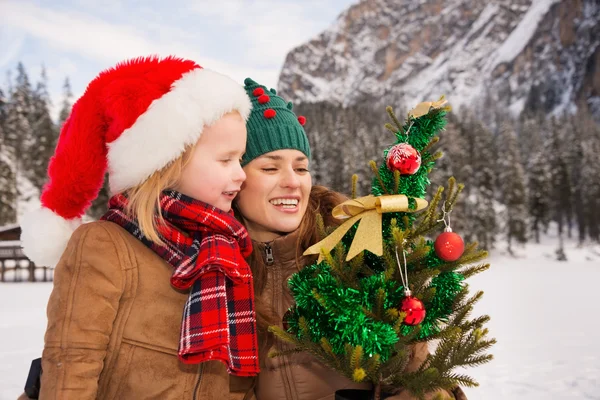 Mãe e criança olhando na árvore de Natal na frente das montanhas — Fotografia de Stock