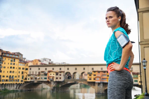 Fitness woman in sportswear staying next to Ponte Vecchio bridge — ストック写真