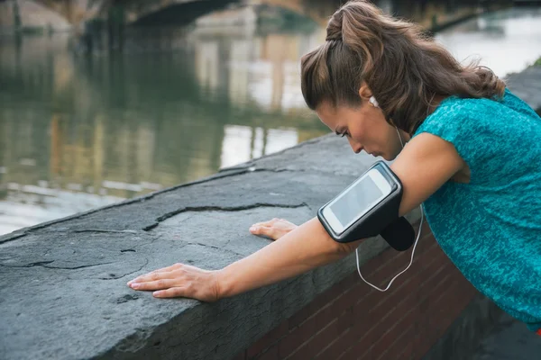 Young woman in sportswear and with mp3 catching breath — 스톡 사진