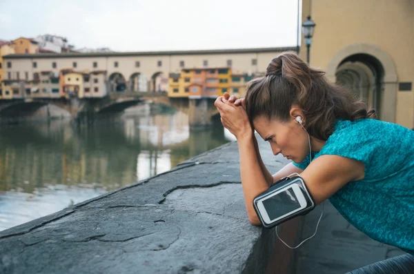 Thoughtful athletic female staying next to Ponte Vecchio bridge — Stockfoto