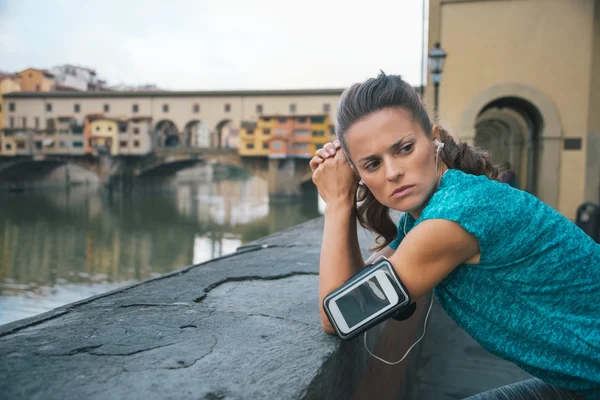 Sportswoman with headset staying in front of Ponte Vecchio — Φωτογραφία Αρχείου