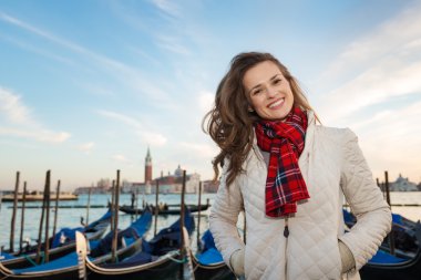 Portrait of happy woman traveler on embankment in Venice, Italy
